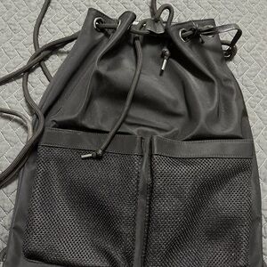 Black Drawstring Backpack with Distinct Compartments and Textured Design